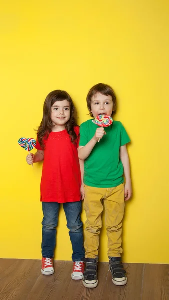 Barnen njuter av lollipop — Stockfoto