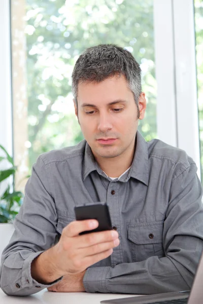 Hombre joven usando el teléfono celular — Foto de Stock