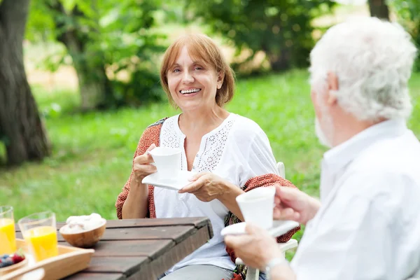 Pareja mayor disfrutando de una taza de café al aire libre — Foto de Stock