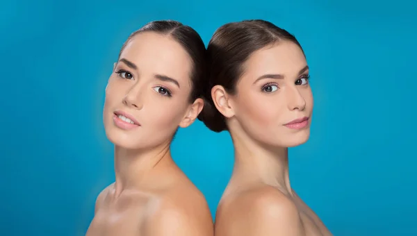 Piękny Portret Dwóch Młodych Kobiet Patrzących Kamerę Niebieskim Tle — Zdjęcie stockowe