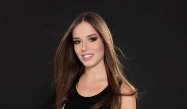 Siyah arka planda siyah elbise giyen genç bir kadının portresi.