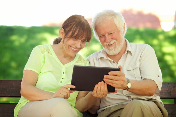 Пенсионеры, использующие планшет — стоковое фото