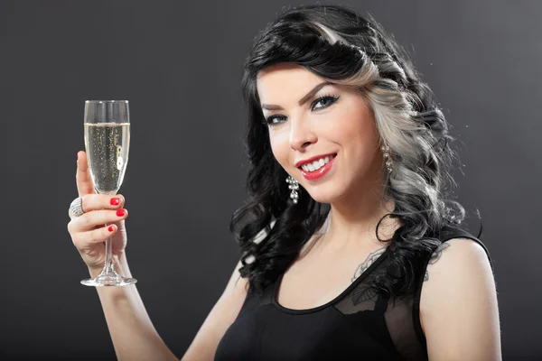 Beautiful young woman celebrating with a glass of champagne — Stock Photo, Image