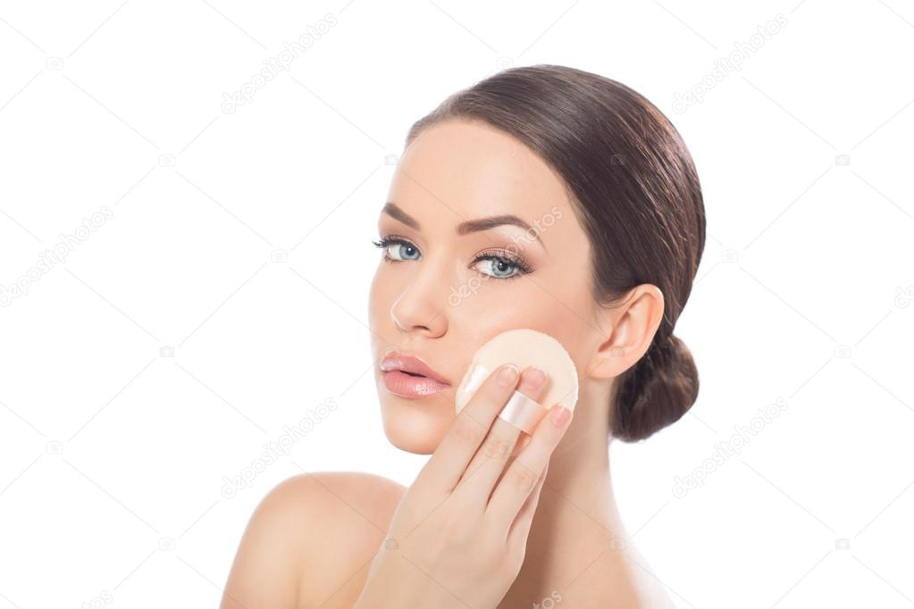 Model applying foundation on her face