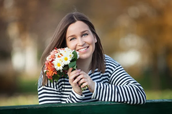 Jeune femme avec un tas de fleurs sauvages — Photo