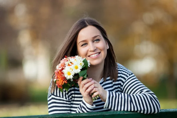 Jovem com cacho de flores silvestres — Fotografia de Stock