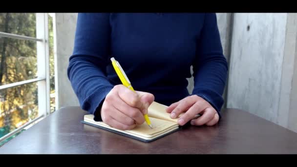 Žena Modrým Svetrem Píše Zápisníku Venku Balkóně — Stock video