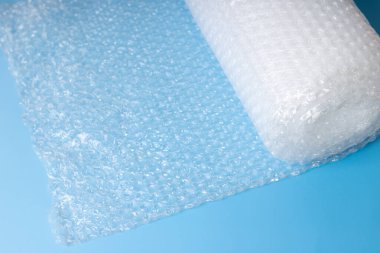 Mavi arkaplanda ambalaj ve ambalaj için kullanılan baloncuk ambalajı rulosu