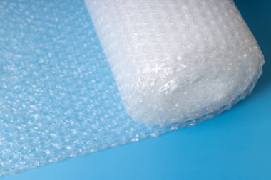 Mavi arkaplanda ambalaj ve ambalaj için kullanılan baloncuk ambalajı rulosu