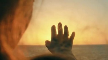 Kız elini güneşe uzatıyor..