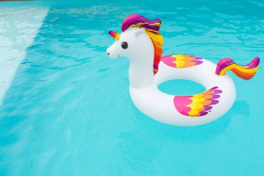 Havuzda renkli tek boynuzlu at şeklinde şişirilebilir yüzer.