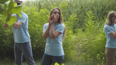 Endişeli erkek ve kadın gönüllüler yaz parkında ya da açık havada birini arıyorlar. Genç beyaz adam ve kadınlar çalılıklarda yürüyor ve kayıp evcil hayvanlara veya kaçırılan çocuklara sesleniyorlar..