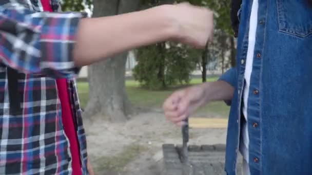 屋外で2人の男子生徒の現代的な握手。学校の庭で勉強する前または後の会議として手を振ると拳をぶつける認識できない白人の少年。Z世代の友情. — ストック動画