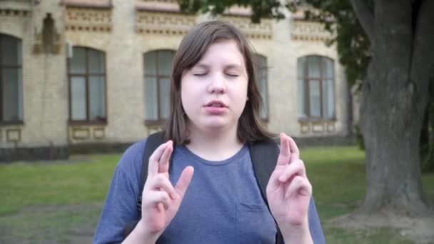 Plump Caucasian boy with closed eyes showing hope gesture and talking. Close-up portrait of hopeful little brunette boy praying for better marks for exam. Education and childhood. — Stock Video