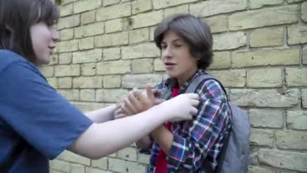 Gepest schooljongen vechten met agressieve jongen op het schoolplein. Portret van een bang pestslachtoffer en dader buiten. Conflict van blanke klasgenoten. Levensstijl en bedreigend concept. — Stockvideo