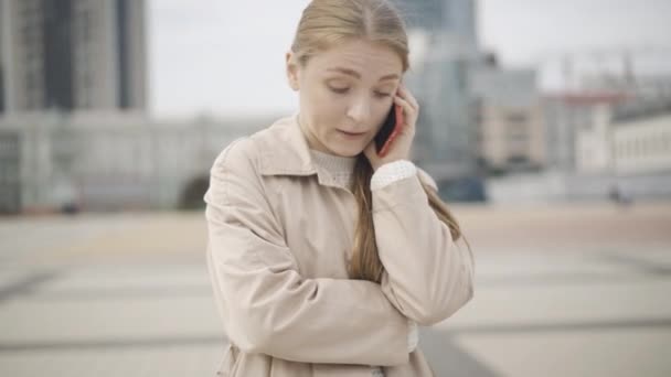 Retrato de jovem mulher nervosa gritando com smartphone e partindo. Senhora caucasiana stressada a ter uma conversa desagradável na praça da cidade. Stress e tecnologias modernas. — Vídeo de Stock