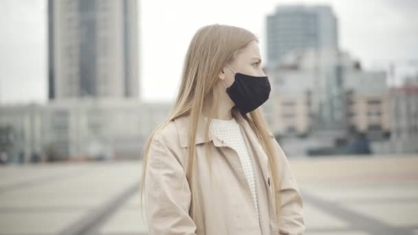 Young confident woman in Covid face mask stop friend from hugging. Portrait of beautiful Caucasian friends meeting on city square during coronavirus pandemic outbreak. Lockdown restrictions. — Stock Video