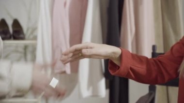 Atölyedeki iki zayıf, genç beyaz kadının el sıkışması. Memnun müşteri ve profesyonel tasarımcı terzi içeride el sıkışıyor. İyi anlaşma ve moda konsepti.