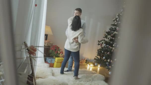 Ampla foto de casal caucasiano feliz dançando em casa na véspera de Natal. Reflexão no espelho de homem sorridente e mulher desfrutando de feriados de Ano Novo dentro de casa. Alegria e conceito de amor. — Vídeo de Stock