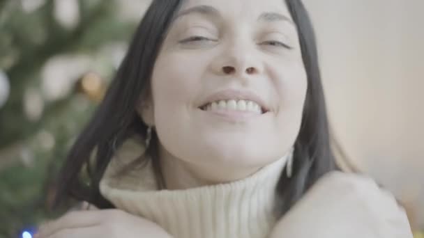 Detailní záběr na okouzlující bělošku, jak posílá vzdušný polibek na kameru a usmívá se na Štědrý den. Snímek hlavy pozitivní veselé dámy oslavující Nový rok doma. Koncept dovolených. — Stock video