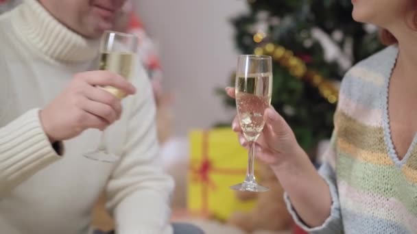 Un cuplu de adulți caucazieni nerecunoscuți care agăță pahare, sărută și beau șampanie sau vin alb în ajunul Anului Nou acasă. Soț și soție iubitori fericiți care sărbătoresc Crăciunul împreună . — Videoclip de stoc