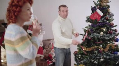 Kafkasyalı sinirli bir adamın Noel ağacını bulanık bir kadın gibi süslediği ve kocasını görmezden gelerek şampanya içtiği portresi. Evde yeni yılı kutlamaya hazırlanan sinirli yetişkin çift..