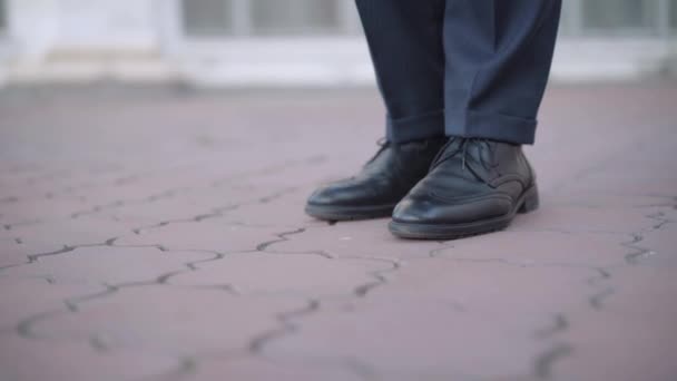 Picior de sex masculin în pantof negru din piele călcând ţigara pe trotuar. Un tânăr de nerecunoscut fumează în aer liber în orașul urban. Obiceiul prost și conceptul de stil de viață nesănătos . — Videoclip de stoc