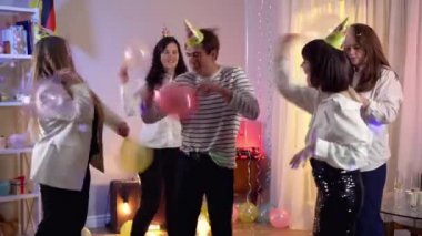 Neşeli milenyum erkekleri ve kadınları doğum günü partisinde balonlarla kavga ediyorlar. Bir grup neşeli Kafkasyalı arkadaş içeride eğleniyor. Boş zaman ve arkadaşlık kavramı.