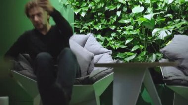 Genç yakışıklı adam dinlenme odasına giriyor ve dizüstü bilgisayarı açıyor. Ciddi derecede başarılı beyaz iş adamının portresi. Modern iş yaşam tarzı.