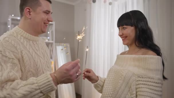 집에서 새 해를 보내는 날 행복 한 젊은 남편과 아내는 참새를 들고 천천히 이야기 한다. 크리스마스를 축하하는 느긋 한 백인 남녀의 모습. 기쁨과 축하. — 비디오