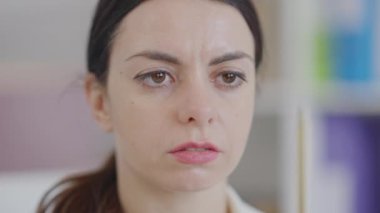 Kaleme ve uzağa bakan genç konsantre bir kadının yakın çekimi. Odaklanmış Kafkas çalışanı ya da CEO 'su ofiste otururken görüş egzersizi yapıyor. Sağlık hizmeti göz egzersizi..