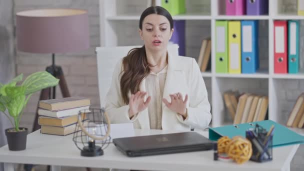 Portret van gestresste, geïrriteerde, jonge vrouw die rustig op kantoor zit met ademhalingsoefeningen. geïrriteerd slank mooi blank werknemer of CEO inhaleren en uitademen mediteren binnen. — Stockvideo