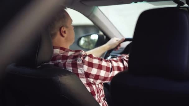 Tir depuis le siège arrière du conducteur caucasien épuisé gifle les joues assis sur le siège du conducteur. Un homme fatigué et surmené qui attend un client en taxi. Épuisement et surmenage. — Video