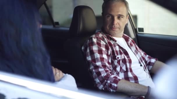 Retrato de un triste hombre caucásico serio sentado en el asiento del conductor discutiendo con una mujer con las manos cruzadas. Marido infeliz peleando con su esposa en el coche. Concepto de problemas de relación. — Vídeos de Stock