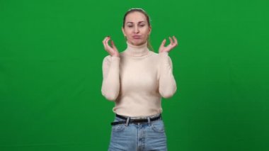 Kendine güvenen profesyonel aktris kromakey arka planında ısınma hareketleri yapıyor. İnce, beyaz bir kadının portresi yeşil ekranda yüz kaslarını ısıtıyor..