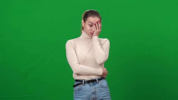Portrait of young shocked woman holding face with hand looking at camera. Dazed Caucasian slim lady with surprised facial expression at green screen chromakey background. — Stock Video