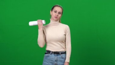 Depresyonda olan bir kadın ağzına krem şanti döküp yeşil ekranda kameraya bakıyor. Kromakey arka planında poz veren güzel beyaz kadın portresi. Ayrılma konsepti.