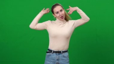 Kromakey arka planında suratını buruşturan komik kadın. Yüzlerini yeşil ekranda eğlendiren neşeli beyaz kadın portresi. Boş zaman ve mutluluk konsepti.