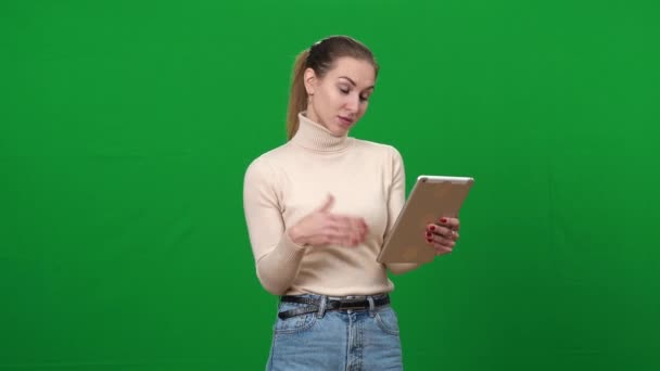 Olumlu genç bir kadın Chromakey arka planında tablet üzerinde görüntülü sohbet kullanıyor. Yeşil ekranda konuşan ve gülümseyen mutlu beyaz kadın portresi. Kablosuz iletişim ve modern teknolojiler. — Stok video