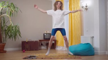 1990 'larda evde aerobik yaparken motivasyonu yüksek genç bir adamın zıplaması. 1980 'lerden kalma beyaz bir adam içeride eğitim görüyor. Klasik jimnastik ve yaşam tarzı.