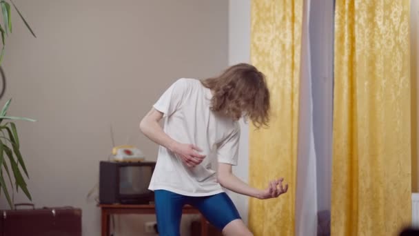 Joven flaco absorto imitando tocar la guitarra en casa retro en el interior. Retrato de músico caucásico creativo absorto de los años 80 y 90 disfrutando de la música en casa. Concepto de estilo vintage. — Vídeos de Stock