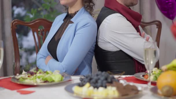 Couple méconnaissable assis dos à dos à la table de Valentines. Argued adulte caucasien homme et femme avec les mains croisées querellées pendant les vacances romantiques. Concept de conflit. — Video