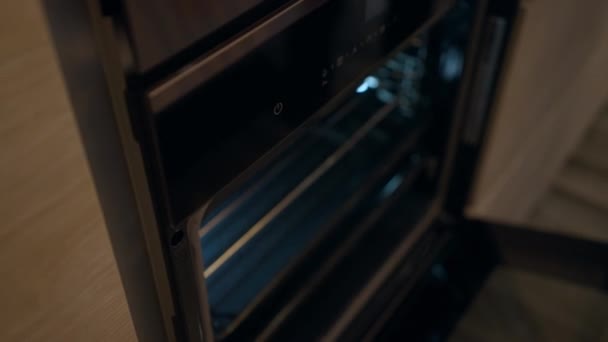 Mão macho abrindo nova porta do forno puxando para fora assadeira. Câmera ao vivo mostra dentro de limpo brilhante moderno aparelho doméstico preto. Conceito de cozinha e tecnologia. — Vídeo de Stock