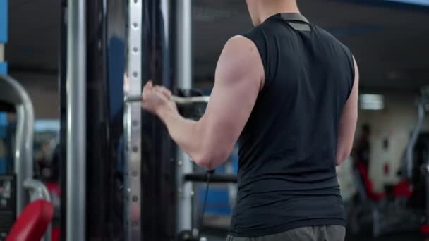 Vedere din spate a sportului de nerecunoscut se potrivesc biceps de formare pe masina de exercitii in sala de sport. Un tânăr caucazian motivat, încrezător, care lucrează în interior. Conceptul de sport și stil de viață . — Videoclip de stoc