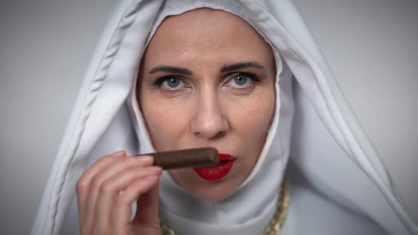 카프카스 수녀의 머리 사진에는 웃고 있는 담배 냄새가 나고 있다. 빨간 립스틱을 바르고 담배 제품을 넣어 포즈를 취하고 있는 자신 감넘치는 멋진 여성의 사진을 클로즈업 한 사진. — 비디오