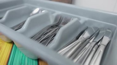 Kapalı alandaki self servis kantinine yakın çekim çatal bıçak takımı. Kafeteryadaki konteynırda çatal kaşıklar ve bıçaklar var. Öğle ve akşam yemeği konsepti.