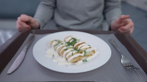 Pancake goreng manis dengan topping di piring dengan pria tak dikenal menggosok tangan mengambil garpu dan pisau untuk memotong makanan penutup. Siswa muda Kaukasia makan di kantin kantin di dalam ruangan. — Stok Video