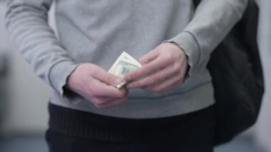 Kapalı mekanda dolar sayan genç erkek eller. Serbest çalışma planlama gelirleri için ödeme yapan tanınmayan beyaz erkek öğrenci. İş ve para kavramı.