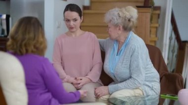 Kızgın, hoşnutsuz, öfkeli büyükanne ve anne üzgün, stresli genç kadına bağırıyor ve depresif, güzel milenyum kamerasını geride bırakıyor. Kafkasyalı çok nesilli ailenin evdeki çatışması.