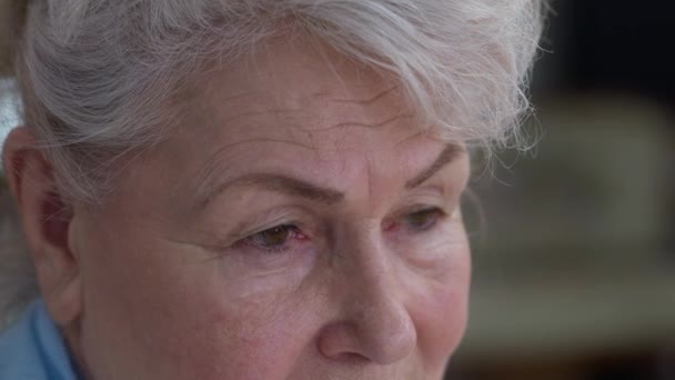 Mata close-up dari depresi wanita tua yang putus asa berpaling dan melihat ke kamera. Sad frustrasi perempuan Kaukasia pensiun berpose dengan ekspresi wajah putus asa di dalam ruangan. Konsep penuaan. — Stok Video